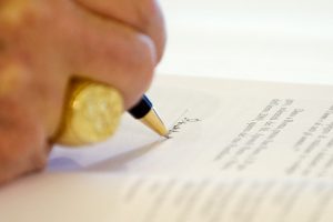Pope Benedict XVI signs a copy of his encyclical, "Caritas in Veritate" ("Charity in Truth"), at the Vatican July 6. The pope's social encyclical, released July 7, addresses the global economic crisis. PHOTO: CNS/L'Osservatore Romano via Reuters