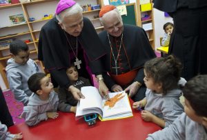 US Cardinal Edwin O’Brien, right, and Auxiliary Bishop William Shomali of Jerusalem, visits with kindergarteners in Beit Sahour on November 28.