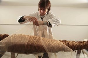Cinzia Oliva, a textile restorer from Turin, Italy, who specialises in mummy wrappings, puts the finishing touches on restoring the mummy Ny-Maat-Re in the Vatican Museums’ collections. PHOTO: Vatican Museums