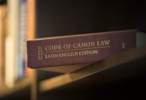 A Latin-English edition of the Code of Canon Law is pictured on a bookshelf. PHOTO: CNS
