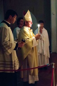 Archbishop Timothy Costelloe holds his candle during the liturgy of light at the commencement of the Easter Vigil at St Mary’s Cathedral on 26 March 2016. Photo: Ron Tan.