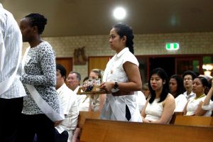 Ryen Osorio participates in the Offertory Procession during the Easter Vigil at St Thomas More Parish in Bateman. Photo: Michael Chong