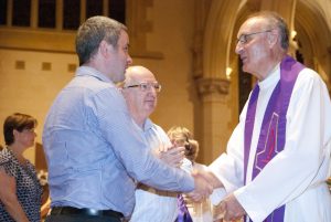 Mgr Tim Corcoran welcomes a candidate preparing to enter the Catholic Church as Mr Hugh Ryan, looks on. PHOTO: Matthew Biddle