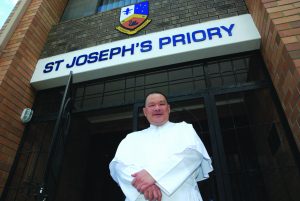 Norbertine Deacon Christopher Lim stands in front of his community’s priory in Queens Park. PHOTO: Robert Hiini