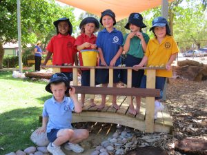 Good Shepherd’s pre-primary and kindergarten students man the pump and hold the bridge in their new nature playground. PHOTO: Peter Rosengren