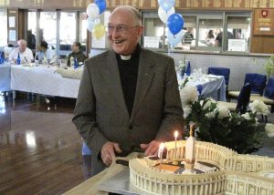 Fr Brian Morgan enjoys the moment and the remarkable ‘Vatican’ cake at his 80th birthday party.