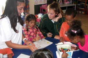 Servite College Year 9 students Sienna D’Orazio (left) and Bree Colotti (right) assist children at a day care run by Kora, a charitable organisation of the Servite Sisters, Photo: Supplied