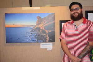 Vaughan with one of his photographs at a recent exhibition at City Farm. PHOTO: Supplied