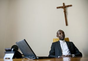 Father Caesar Atuire, chief executive officer of Opera Romana Pellegrinaggi, a Vatican-related pilgrimage agency, talks about the pilgrim experience in his Rome office.