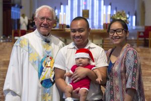 Dean of St Mary’s Cathedral Monsignor Michael Keating reads to young worshippers during the Children’s Mass on Christmas Day. Photo: Ron Tan