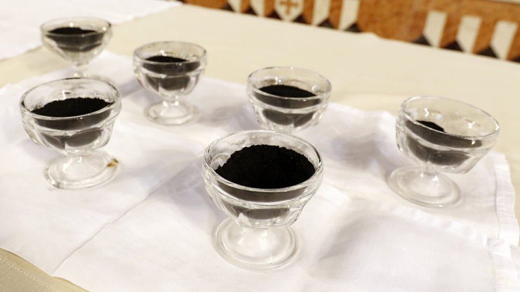Glass cups containing ashes on an altar.