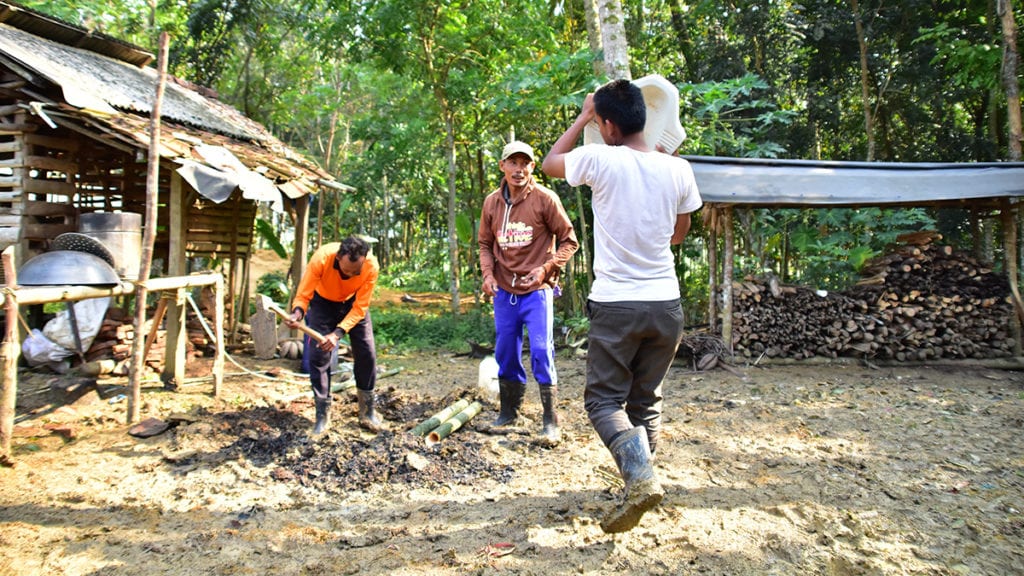 Three Indonesian men building a pit latrine.