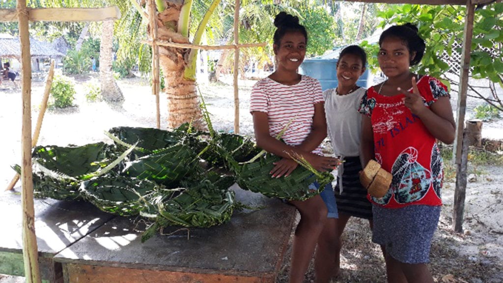 3 Kiribati girls with woven baskets.