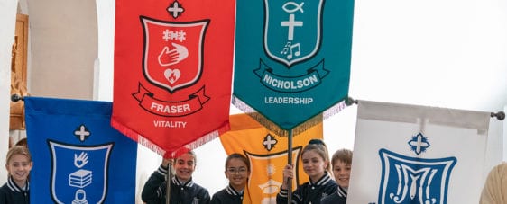 Students holding the school house flags.