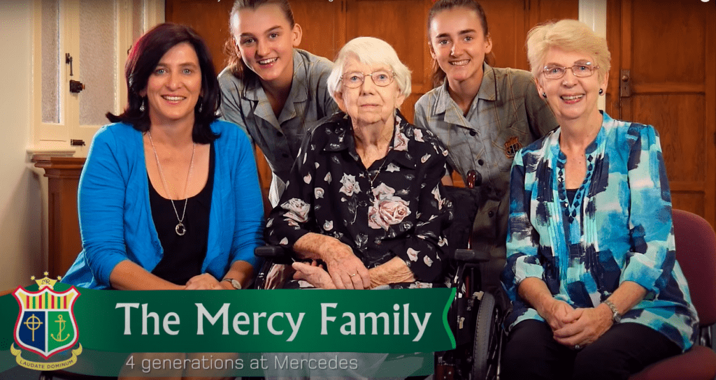 An old lady sits smiling in a wheel chair, to her left is a lady in her 60's, to her right, a middle-aged lady, while behind her are two highschool students, sisters. All of whom, attended Mercedes College.
