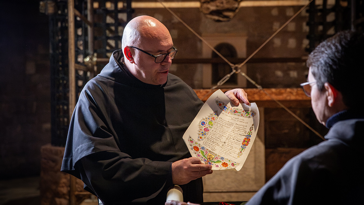 A monk from the local Franciscan community holds a document from the 1978 scientific examination of the relics of St. Francis, which were exhumed from their shrine in the Basilica of St. Francis in Assisi, Italy, Feb. 21, 2026, prior to being displayed for public veneration starting Feb. 22. Veneration runs through March 22. Photo: OSV News/courtesy Sala Stampa Sacro Convento Assisi.

