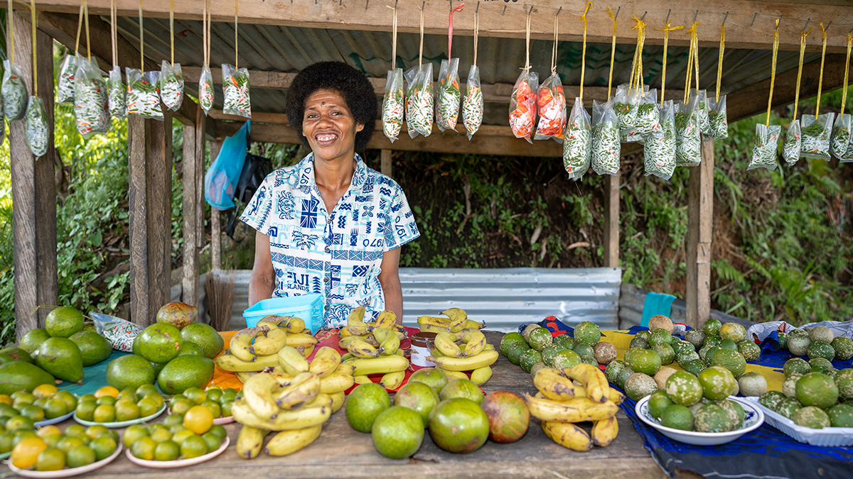 Manaini with some of the produce she is able to sell from her roadside stall. Photo: Caritas Australia.