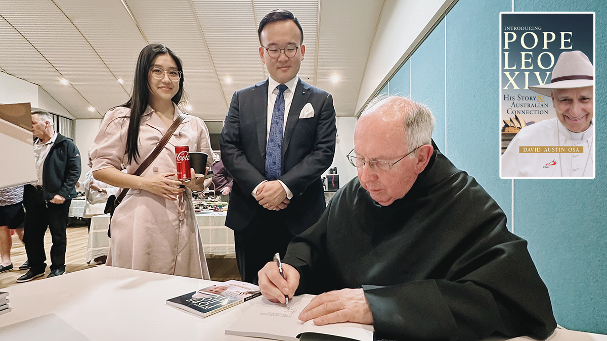 Fr Dave Austin signs a copy of his book for Fiona Choi and James Lu whose photo of Pope Leo XIV wearing an Akubra hat is featured on the cover of the book.