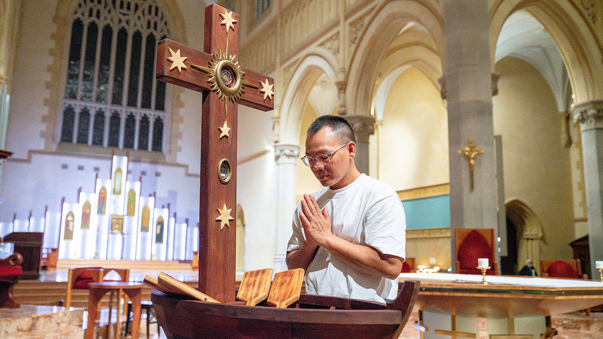 A parishioner prays before the Migrant Jubilee Cross at the conclusion of Mass. Photo: Eric Odong/Archdiocese of Perth.