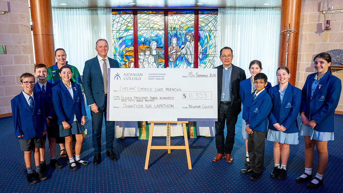Bishop Nelson and Principal Andrew Watson join with the students to present and accept the donation cheque. Photo: Eric Odong/Archdiocese of Perth.