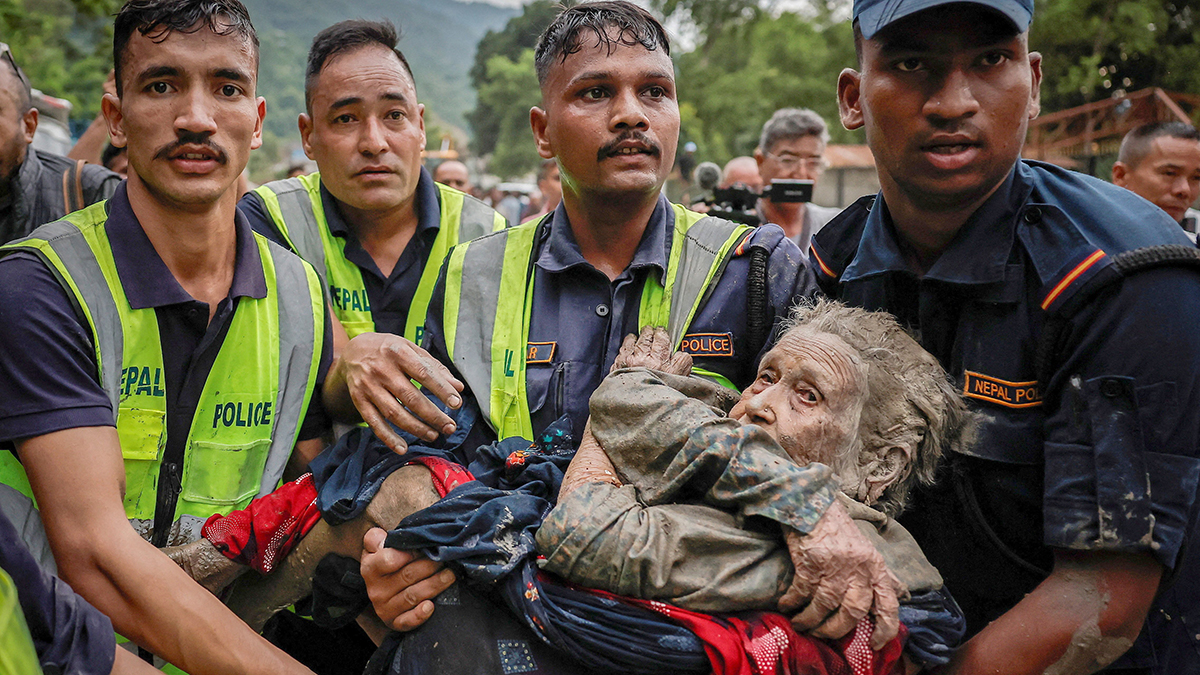 Police officers carry an elderly survivor to a safer place at Devighat in Nepal's Nuwakot district, on 30 August 2026, following deadly flash floods and mudslides. The combined deaths in Nepal and China surpassed 950, with more than 4000 people missing. Photo: OSV News/Navesh Chitrakar, Reuters.