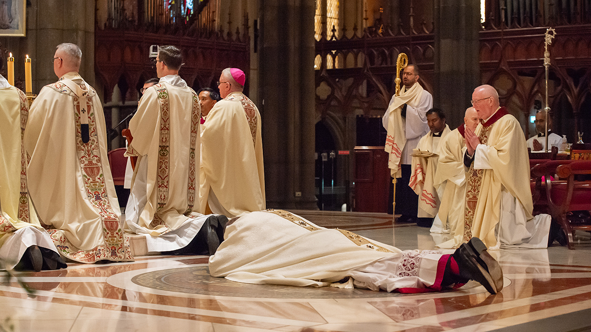 Military Ordinariate bishop-elect Stuart Hall lays prostrate during the Litany of the Saints at his Episcopal Ordination, Saturday 29 August at Melbourne’s St Patrick’s Cathedral. Photo: Peter Casamento.